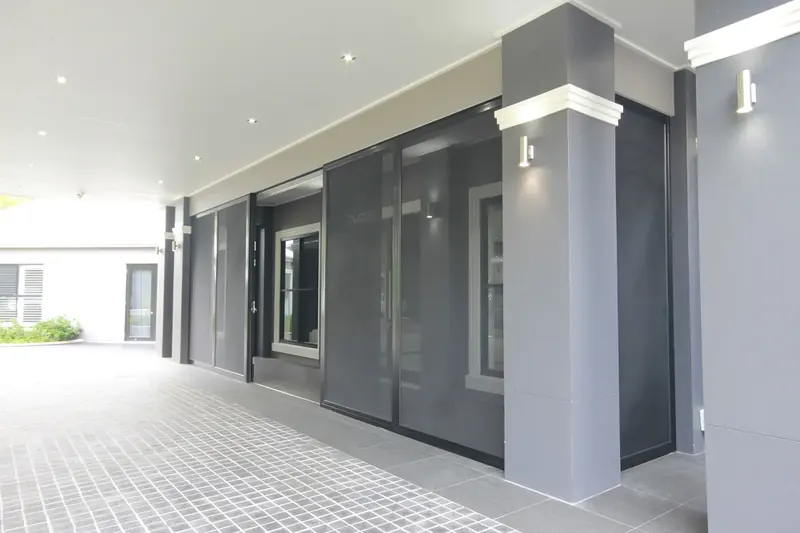 Black security mesh screens closed across a row of sliding doors on a covered patio